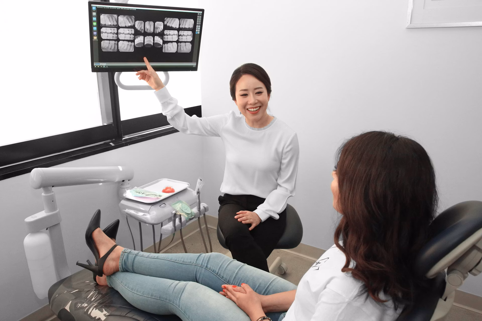Dr. Oh pointing to a monitor with a patient